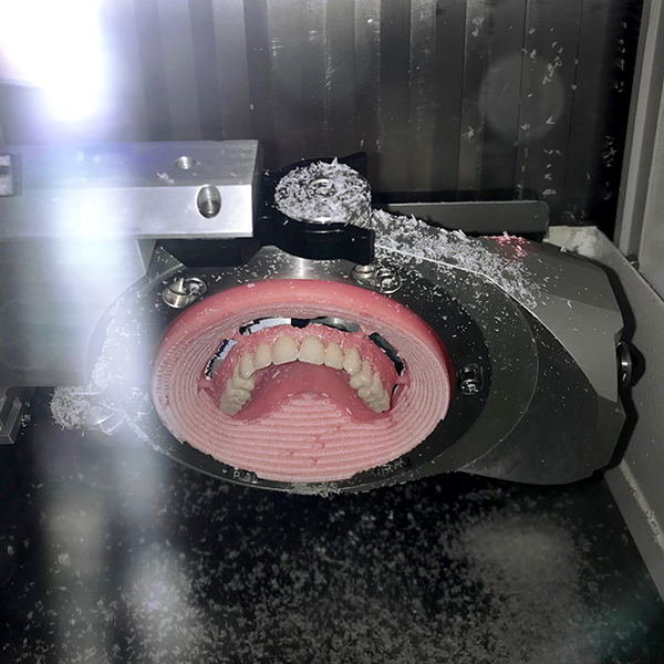Afbeelding 3 freesmachine aan het werk met gebitsprothese / kunstgebit  van de Gebittenmaker